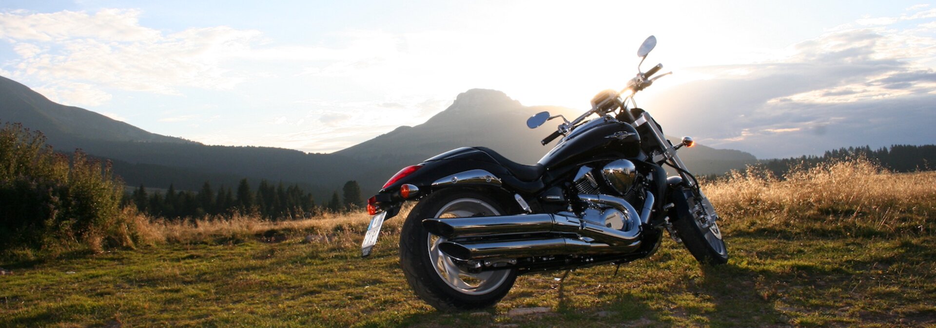 Motorrad vor Berglandschaft im Sonnenuntergang