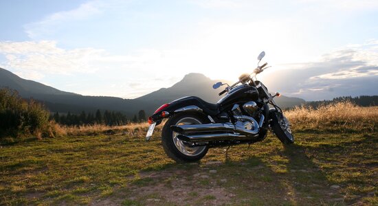 Motorrad vor Berglandschaft im Sonnenuntergang