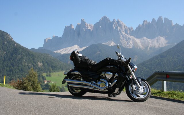 Motorradfahrer liegt auf Bike vor den Dolomiten