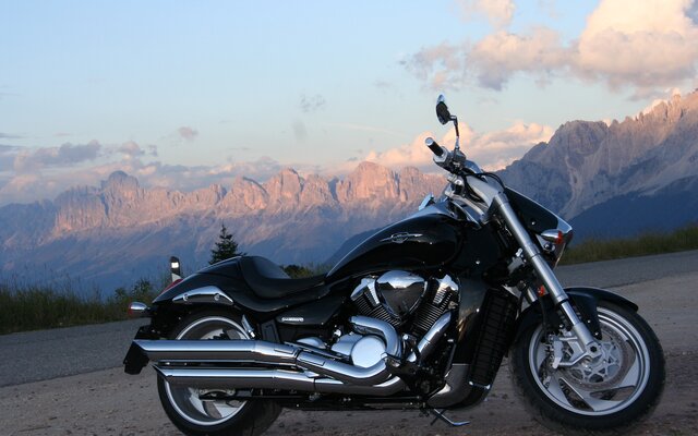 Schwarzes Motorrad vor Bergkulisse geparkt