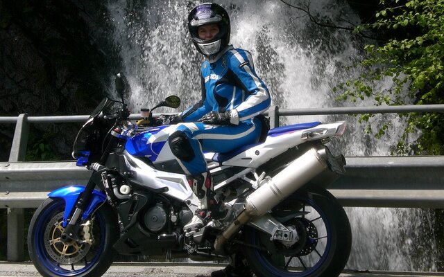 Biker auf seinem Motorrad vor Wasserfall
