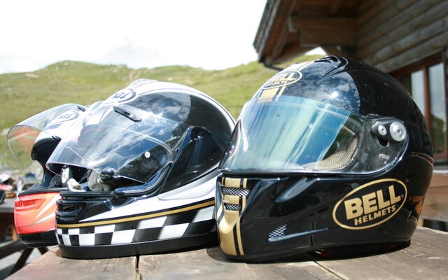 Bunte Motorradhelme auf Holztisch abgelegt