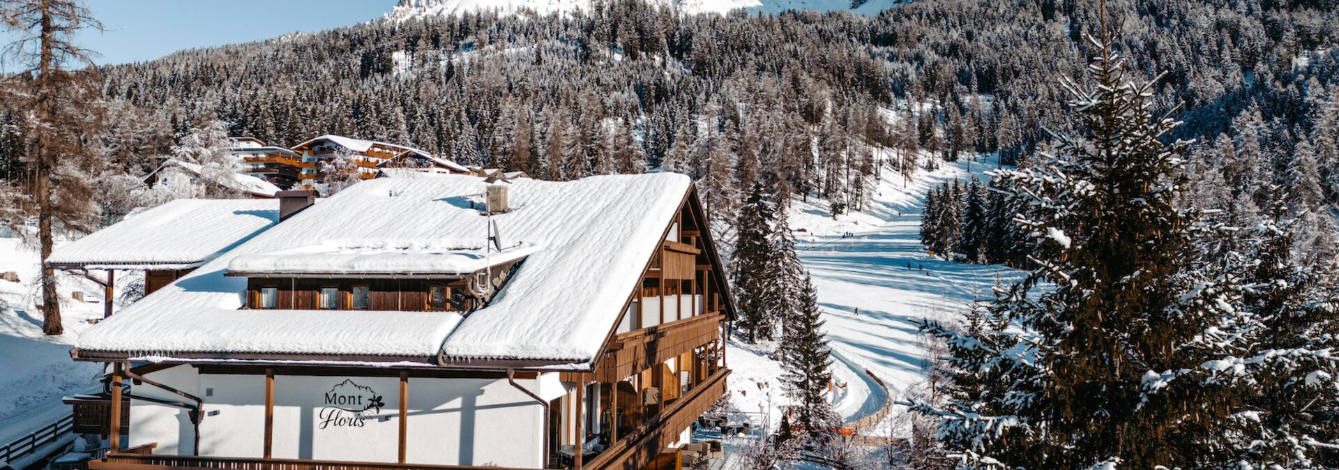 Hotel innevato Mont Floris davanti a paesaggio alpino