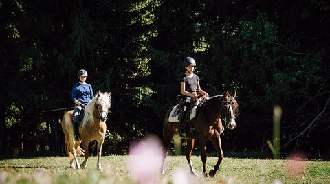 Two young riders on a trail ride through nature
