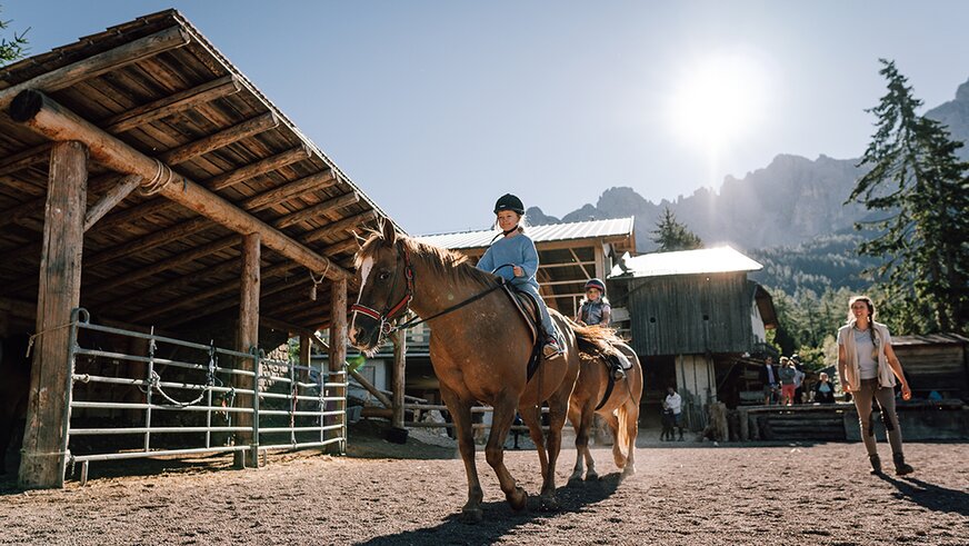 Horse riding lesson for children under the mountain sun