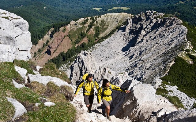 Due escursionisti in salita tra le rocce di montagna