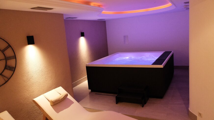 Vasca idromassaggio con luci soffuse e zona relax.