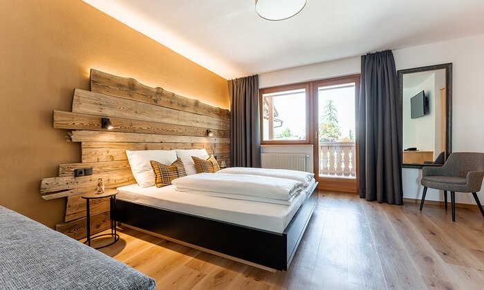 Letto con testata in legno, finestra e arredamento moderno.