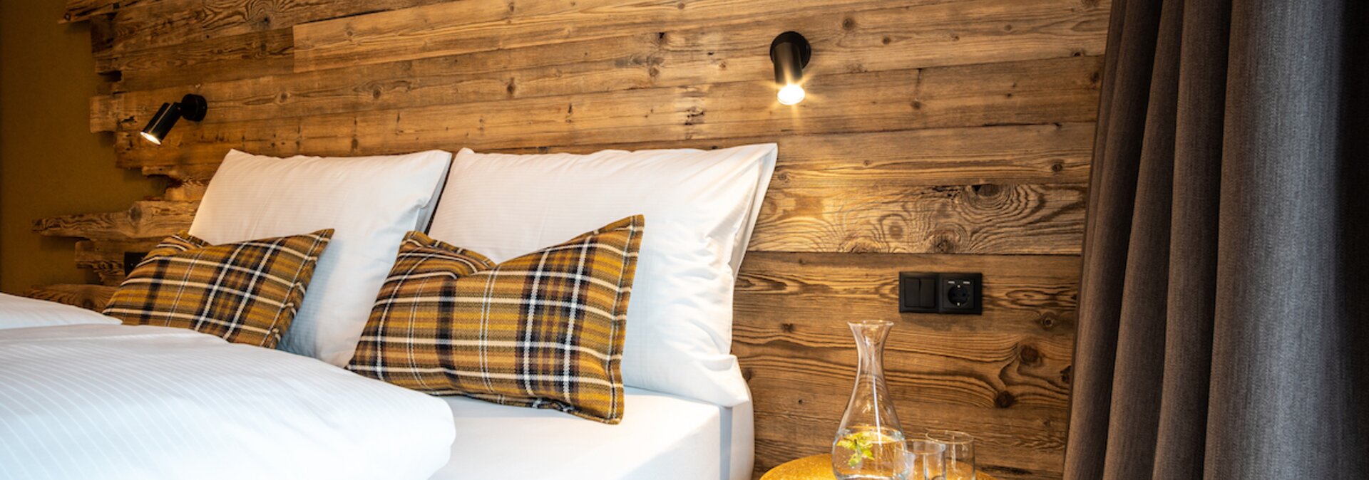 Bed with pillows and table with water carafe.